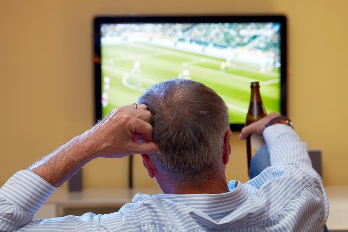 Mature Man Watching Football On Tv